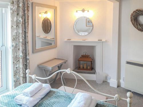 达特茅斯Silver Cottage的一间卧室配有一张床、镜子和壁炉