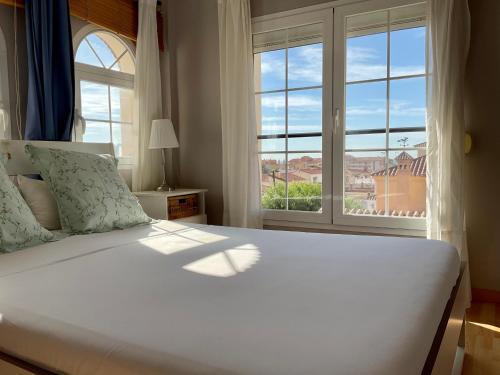 林孔-德拉维多利亚At Home in Malaga Stay & Solo Travellers的卧室设有一张白色大床和一扇窗户。