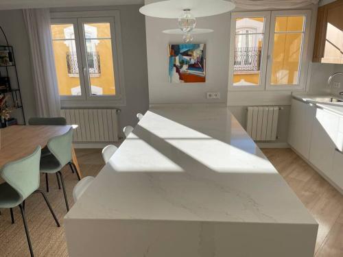 布尔戈斯Burgos Señorial by Exclusive Burgos Apartments的厨房配有白色的柜台和桌椅
