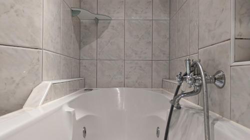 鹿特丹CRASH'NSTAY - Maison du Ville的带淋浴的浴室配有白色浴缸。