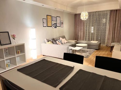 安曼Ronza Elegant Apartment的客厅配有沙发和桌椅