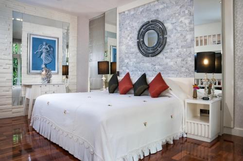 清迈斯瑞姆潘精品度假Spa酒店 - SHA Extra Plus的卧室配有带红色枕头的大型白色床