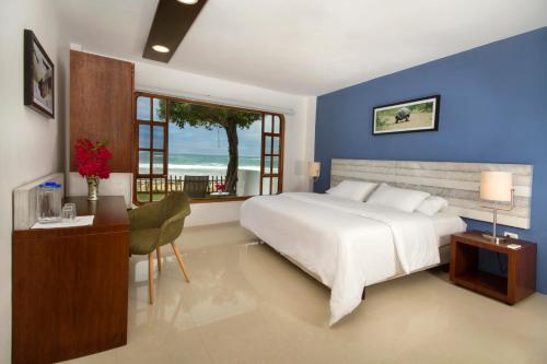 比亚米尔港Casita de la Playa的卧室设有一张白色大床和一扇窗户。