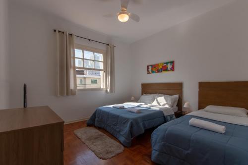 圣保罗Casa no Tatuapé São Paulo - SP的一间卧室设有两张床、一张桌子和一个窗口。