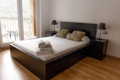 阿林萨尔Apartamento moderno El Bosque en Arinsal的一间卧室配有一张大床和毛巾