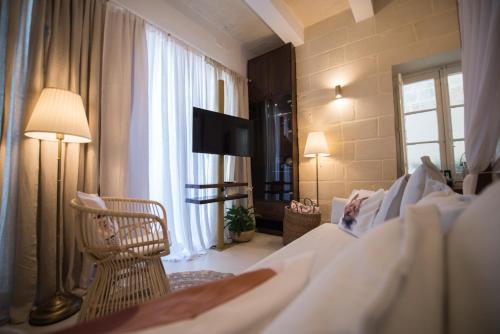 科斯皮夸Casa Maria Tereza的酒店客房配有一张床、一把椅子和一台电视。