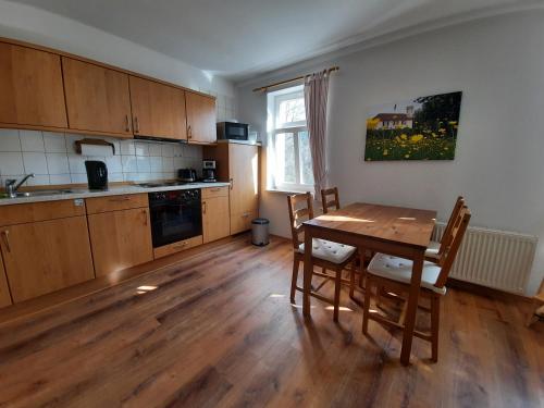 措伊伦罗达Pension Kastanienhof的厨房铺有木地板,配有木桌。