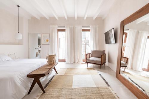索列尔Meem Townhouse的白色卧室配有一张大床和椅子