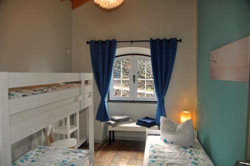UrzelinaAzorenhaus am Atlantik - Family House的一间卧室设有两张双层床和一扇窗户。