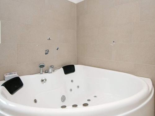 罗莫柯克比12 person holiday home in R m的浴室设有白色浴缸,铺着瓷砖。