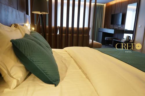 普里兹伦Hotel Credo的一间卧室配有带绿色和白色枕头的床