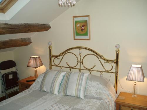 吉斯本Foxhill Barn的一间卧室配有一张带两盏灯和镜子的床