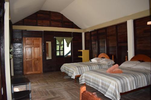 斯普希尔Eco Aldea kinich Ahau的木墙客房的两张床