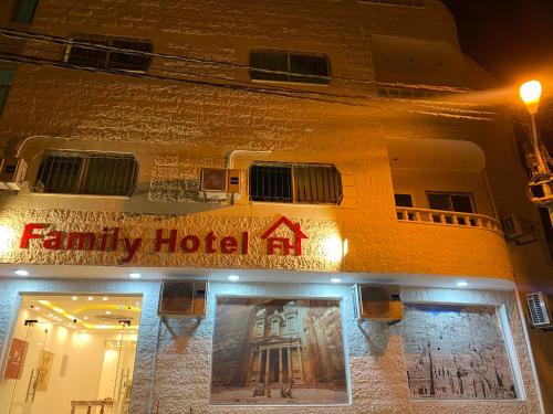 瓦迪穆萨Petra Family Hotel的一家家庭酒店晚上的外墙