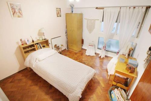 布宜诺斯艾利斯Departamento muy buena ubicacion的一间卧室配有一张床,铺有木地板