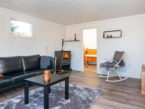 宝可波7 person holiday home in B rkop的客厅配有黑色沙发和壁炉