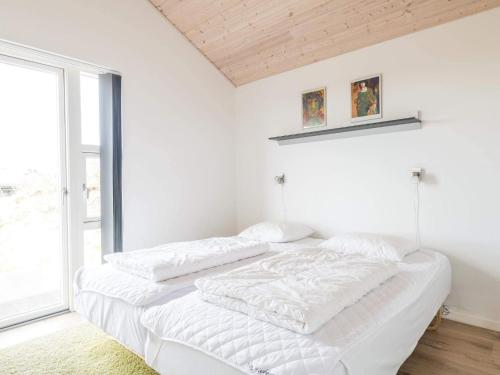 凡岛Holiday home Fanø CLXXIII的窗户客房内的一张白色床