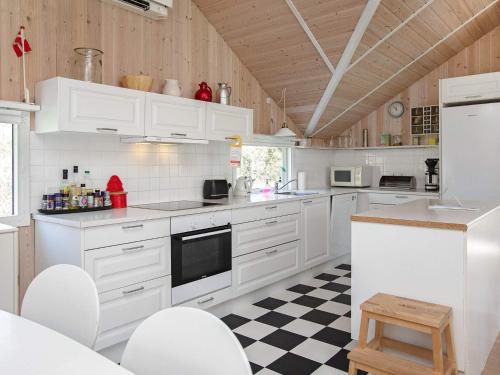 斯泰厄10 person holiday home in Stege的厨房配有白色橱柜和 ⁇ 格地板