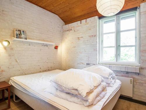 ÅgerupHoliday Home Elvervej的一间卧室配有一张带白色床单的床和一扇窗户。