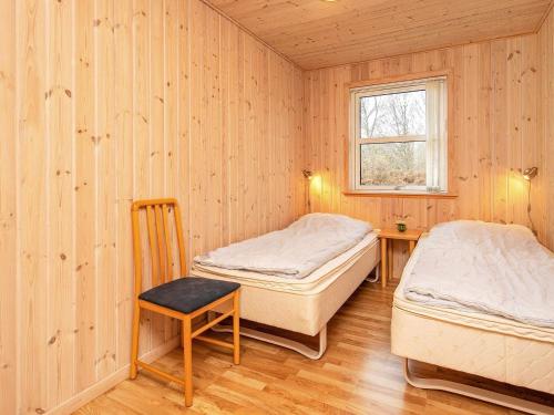 莱斯Holiday home Læsø XX的配有桌子和窗户的客房内的两张床