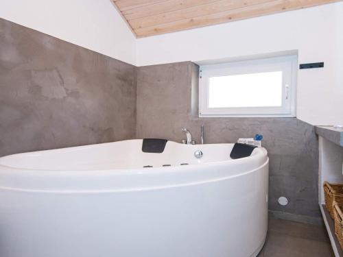 格莱斯堡8 person holiday home in Glesborg的带窗户的浴室内的白色浴缸