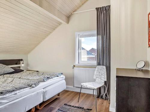 森讷比Apartment Rømø XXXI的卧室配有床、椅子和窗户。