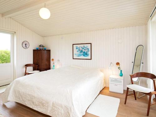 布罗Holiday home Brenderup Fyn IX的卧室配有一张白色大床和两把椅子