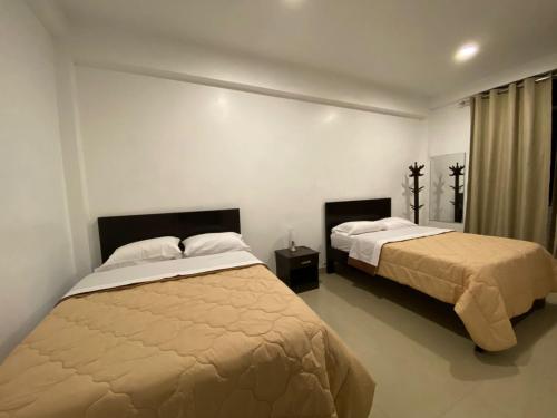 查查波亚斯Santa Lucía Suite Hotel的一间卧室设有两张床和窗户。