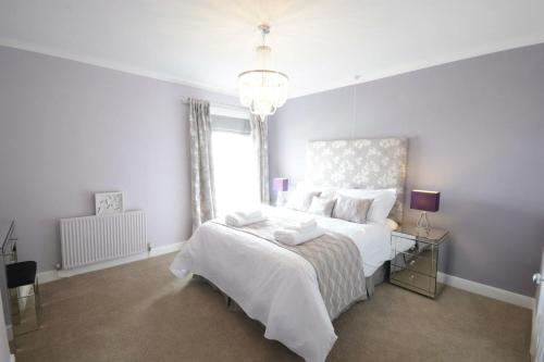 绍斯沃尔德St Marys View, Southwold的卧室设有一张白色大床和一扇窗户。