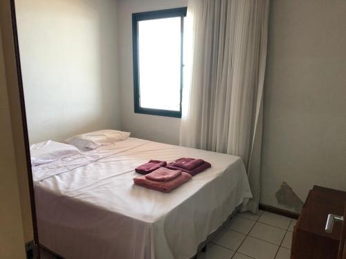 瓜拉派瑞Amplo apartamento em Guarapari com vistas pro mar的一间卧室配有一张床,上面有两条毛巾
