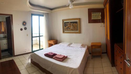 瓜拉派瑞Amplo apartamento em Guarapari com vistas pro mar的一间卧室配有一张床,上面有两条毛巾