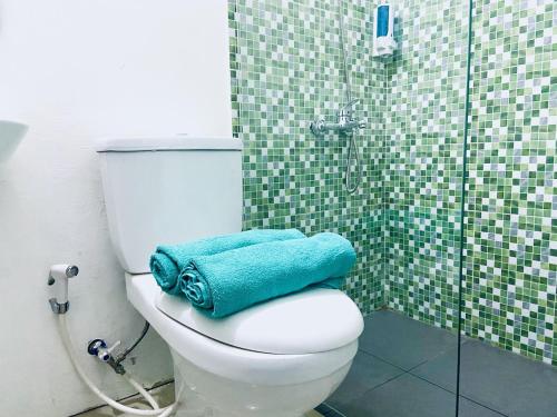 雅加达Ameera Patra Kuningan的浴室设有卫生间,配有蓝色毛巾