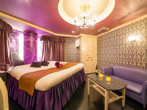 神户图库情趣酒店（仅限成人）的紫色的客房配有一张床和一张沙发