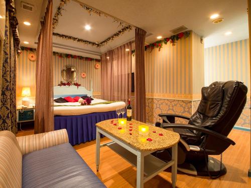神户图库情趣酒店（仅限成人）的配有床、桌子和椅子的房间