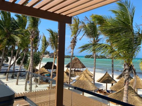 蓬圭TOA Hotel & Spa Zanzibar的享有海滩美景,配有遮阳伞和海洋美景。