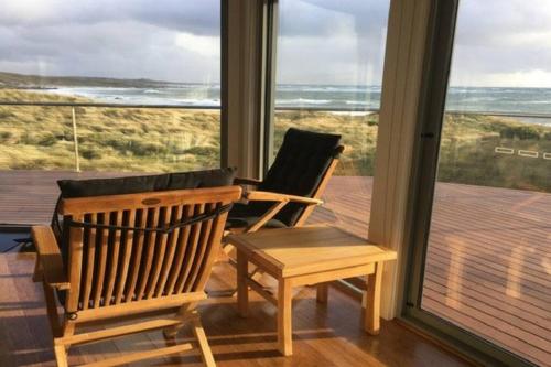 洛拉纳Wave Retreat, King Island的一间设有两把椅子、一张桌子和一个窗户的房间