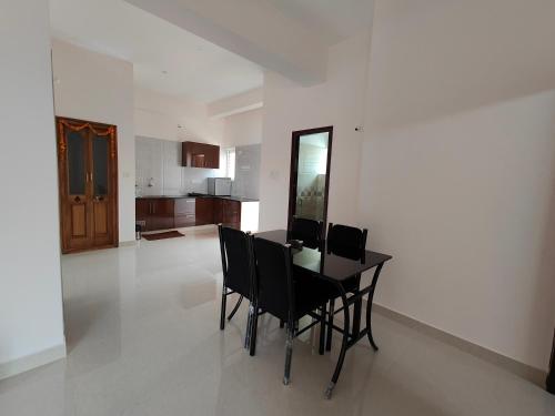 迈索尔Lishan Apartment的一间带桌椅的用餐室和一间厨房