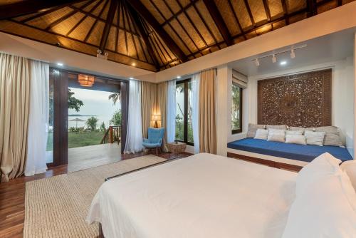 卢纳将军城VILLA JUAN - A Beach Front Villa in General Luna Siargao的一间卧室设有一张大床和一个大窗户