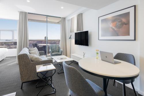 悉尼泽特兰美利通公寓式酒店的酒店客房带一张桌子,上面有一台笔记本电脑