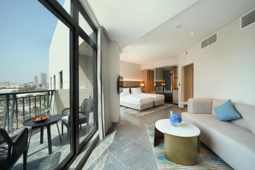 迪拜Arabian Park Dubai, an Edge by Rotana Hotel的带沙发的客厅和卧室