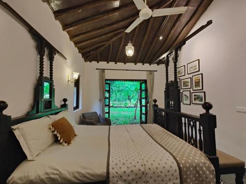 JambhulpādaSaffronStays Mango Huts by the River, Pali的一间卧室配有一张带吊扇的床