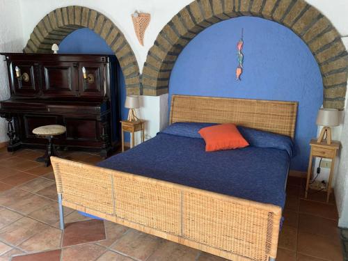潘泰莱里亚Cactus b&b Le casette di Marilena的一间卧室设有一张大床和两个拱门