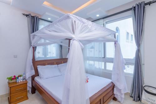 马林迪Cozy Crib的一间卧室设有天蓬床和窗户。