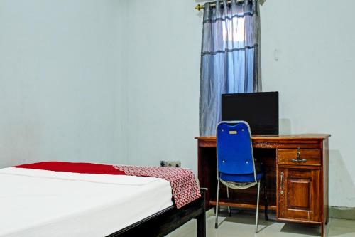 古邦OYO 91720 Hotel Yotowawa的一间卧室配有一张床、一张桌子和一把蓝椅