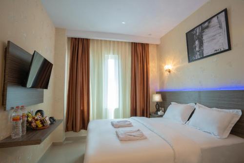 棉兰De'Tonga Hotel的酒店客房设有一张白色大床和一台电视。