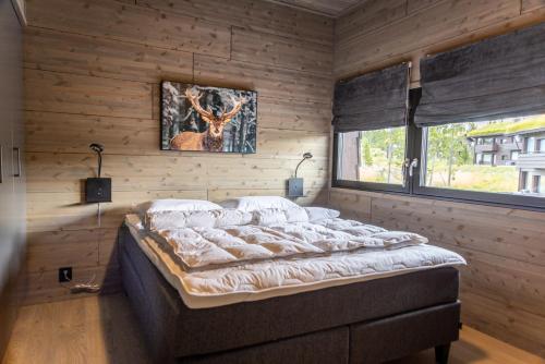 奥耶Mosetertoppen Skiline - Hafjell Ski Resort的卧室配有一张床铺,位于带木墙的房间内