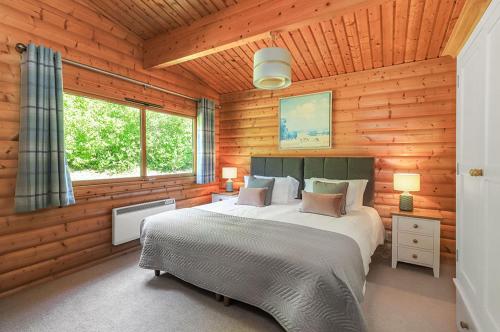 温彻斯特South Winchester Lodges的木制客房内的一间卧室配有一张大床
