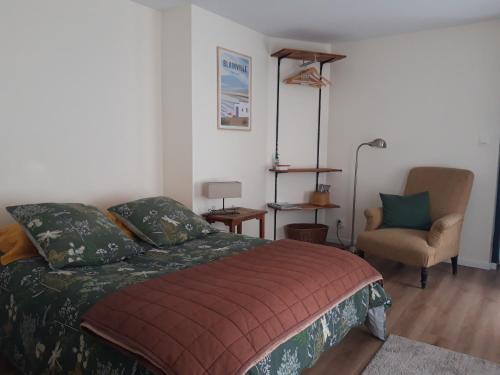 库唐斯Agréables chambres indépendantes - Coutances centre的一间卧室配有一张床和一把椅子