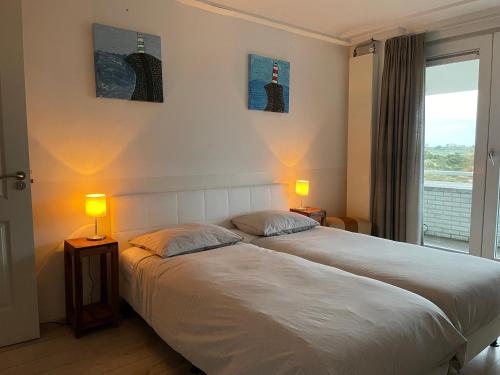 艾默伊登维他命Z住宿加早餐旅馆的一间卧室设有两张床、两盏灯和一个窗户。