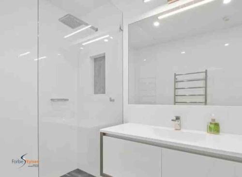 斯瑞德伯Stylish Thredbo Alpine Chalet + Garage in Tranquil Setting的白色的浴室设有水槽和镜子